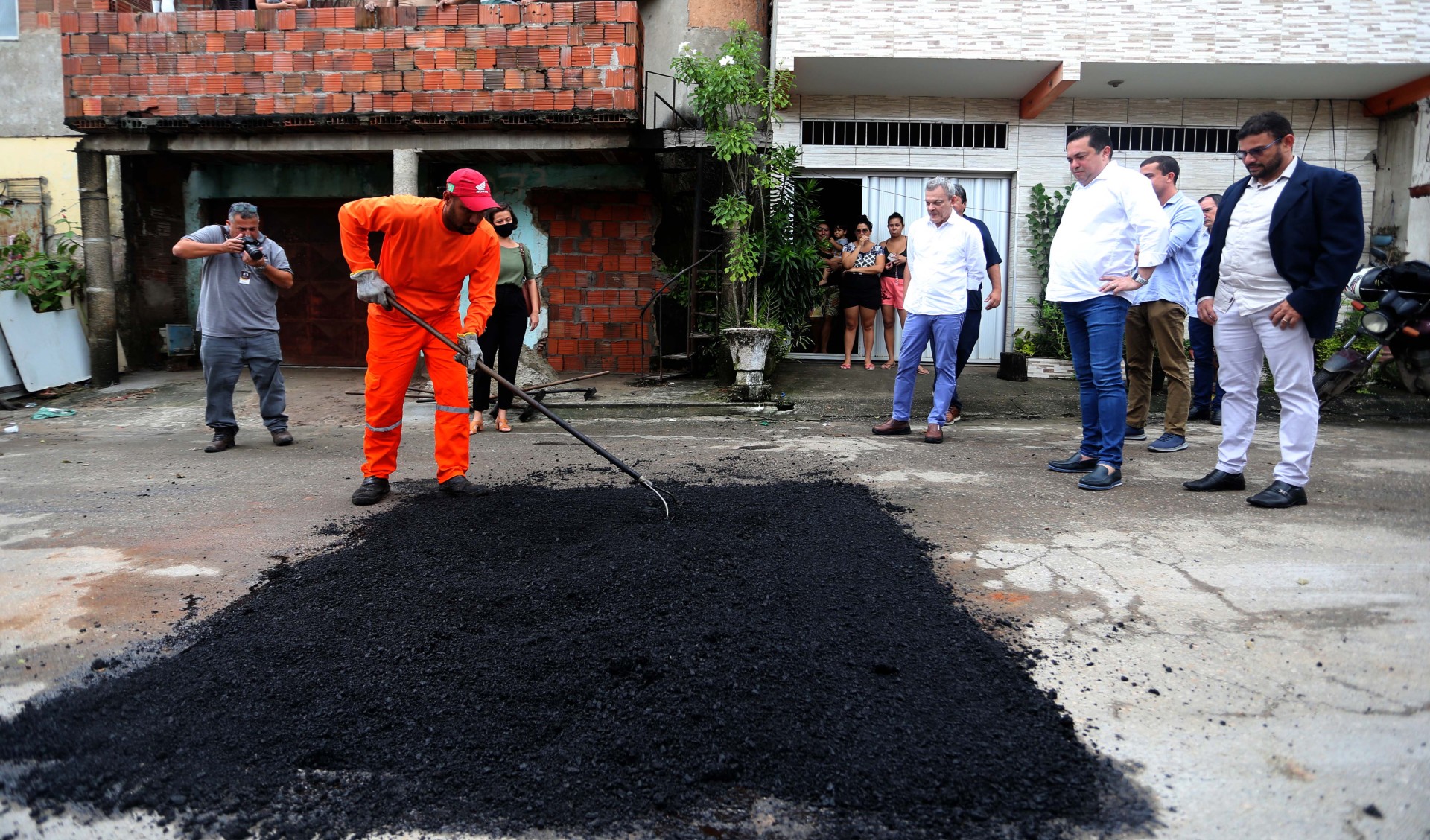 sarto observa homens trabalhando na operação tapa-buracos